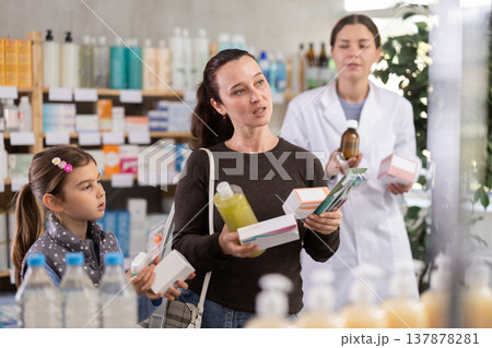 Cheerful mother and daughter shopping at pharmacy Cheerful mother and daughter shopping at pharmacy 137878281