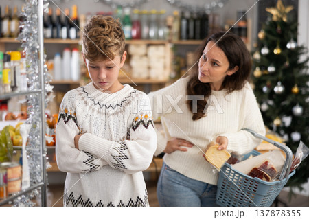 Mom scolds teenage son for bad behavior in grocery supermarket Mom scolds teenage son for bad behavior in grocery supermarket 137878355