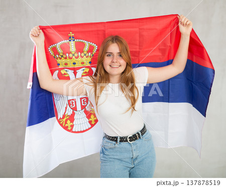 smiling girl in arms raised above head holds cloth of national flag of Serbia smiling girl in arms raised above head holds cloth of national flag of Serbia 137878519