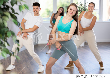 Girl teen perform choreographic exercise and teach energetic house dance with friends 137878576