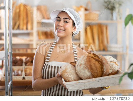 Young woman seller with bread in basket Young woman seller with bread in basket 137878720