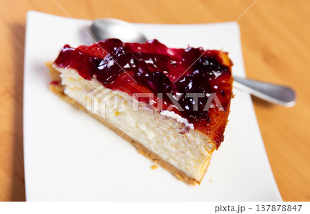 Piece of cranberries cheesecake, drizzled with jam on top 137878847
