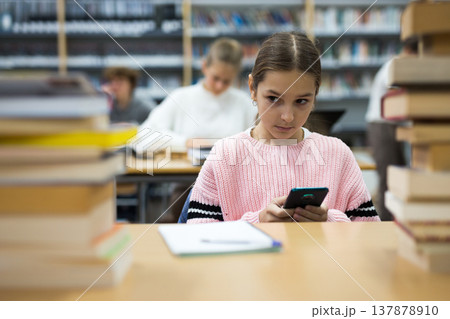 Portrait of a ten-year-old schoolgirl holding a mobile phone 137878910