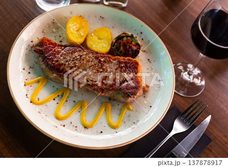 Fried beef meat with boiled potatoes and vegetables closeup Fried beef meat with boiled potatoes and vegetables closeup 137878917