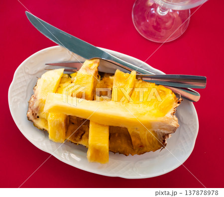 Half of whole pineapple fruit is served on plate Half of whole pineapple fruit is served on plate 137878978