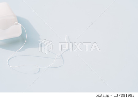 Dental floss coming out of dispenser on light blue background, clean oral care routine concept 137881983