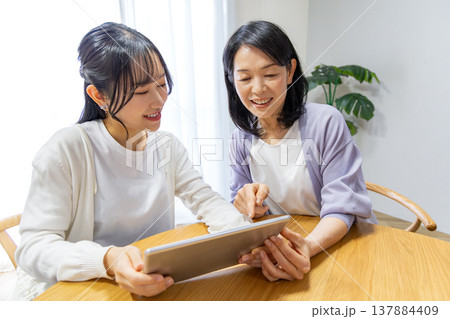 タブレットを使う母娘 タブレットを使う母娘 137884409