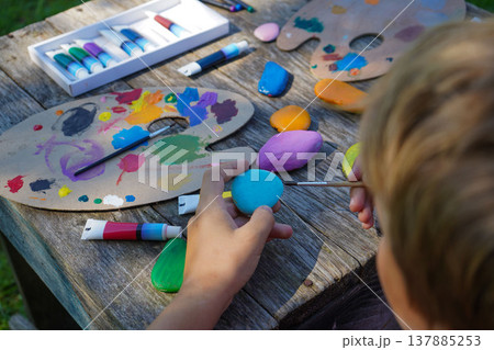 Young painters transform smooth rocks with bright ideas, crafting heartfelt, imaginative gifts for giving. Young painters transform smooth rocks with bright ideas, crafting heartfelt, imaginative gifts for giving. 137885253