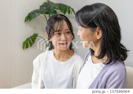 リビングで会話をする仲の良い母娘 137886064