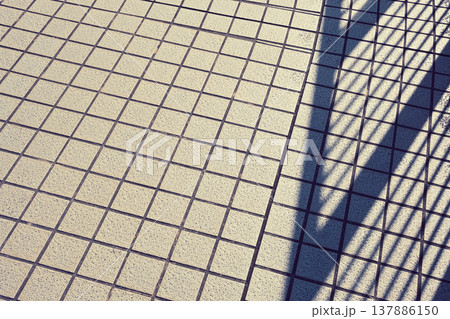 柵の影がかかった歩道の路面 137886150