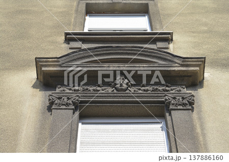 Classical building facade with stone face relief 137886160