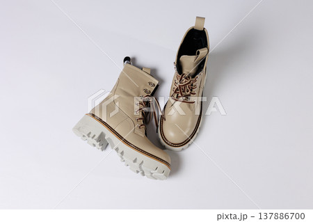 Beautiful beige shoes with genuine leather on an isolated white studio background. Fashionable classic women's boots. Stylish elegant leather shoes. 137886700