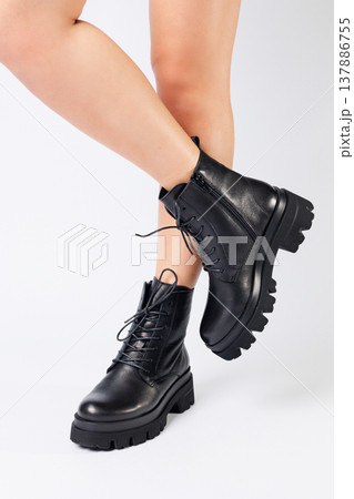 Woman in trendy black shoes on a white background, close-up. Woman's legs in stylish leather shoes Woman in trendy black shoes on a white background, close-up. Woman's legs in stylish leather shoes 137886755