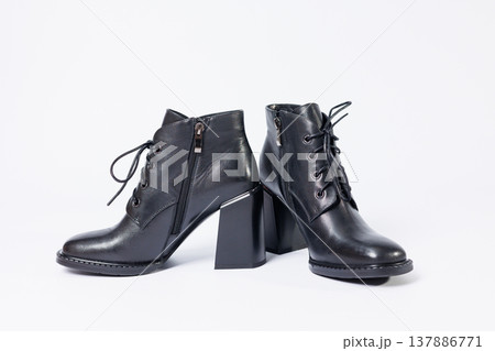 Women's boots with black genuine leather on heels isolated on a white background. photo from the side, diagonally and foreshortened from behind. Women's shoe collection 2022 Women's boots with black genuine leather on heels isolated on a white background. photo from the side, diagonally and foreshortened from behind. Women's shoe collection 2022 137886771
