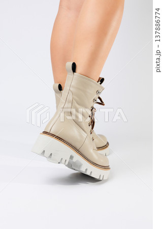 Women's white spring boots made of genuine leather are worn on a woman's leg. New collection of women's boots 2022 Women's white spring boots made of genuine leather are worn on a woman's leg. New collection of women's boots 2022 137886774