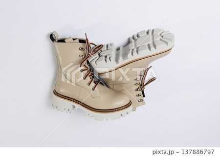Beautiful beige shoes with genuine leather on an isolated white studio background. Fashionable classic women's boots. Stylish elegant leather shoes. 137886797