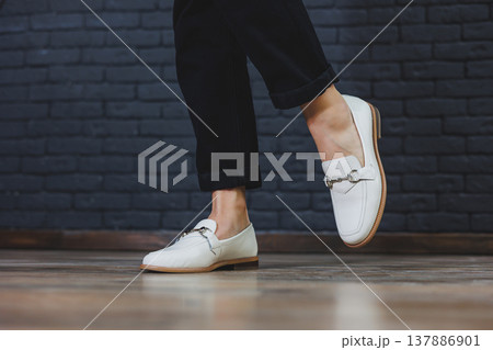 Close-up female legs in black trousers and leather beige moccasins. New spring-summer collection of women's leather shoes 2022 137886901