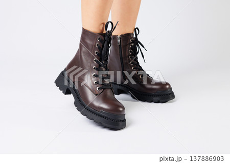 Women's brown spring boots made of genuine leather on a woman's leg. New collection of women's boots 2022 Women's brown spring boots made of genuine leather on a woman's leg. New collection of women's boots 2022 137886903