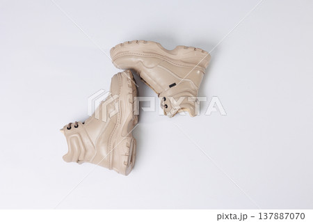 Beautiful shoes on an isolated white studio background. Fashionable beige women's shoe. Elegant stylish footwear. Beautiful shoes on an isolated white studio background. Fashionable beige women's shoe. Elegant stylish footwear. 137887070
