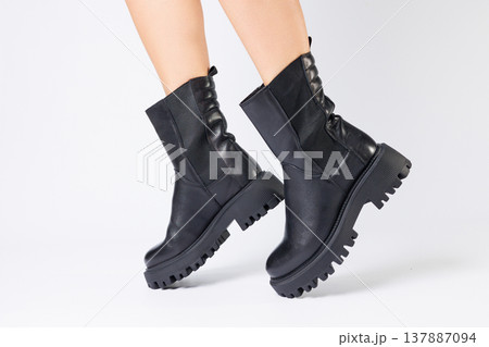 Women's black spring boots made of genuine leather are dressed on bare feet Women's black spring boots made of genuine leather are dressed on bare feet 137887094