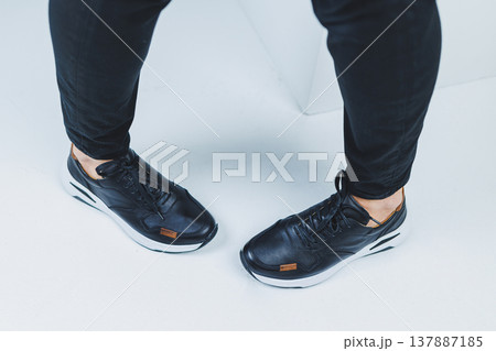 Men's legs in casual shoes of black color made of genuine leather, men on shoes in black sneakers. High quality photo Men's legs in casual shoes of black color made of genuine leather, men on shoes in black sneakers. High quality photo 137887185