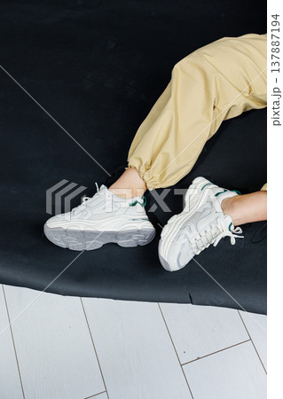 Casual women's fashion. Comfortable shoes for women. Female legs in pants and white stylish casual sneakers. Women's comfortable summer shoes. Casual women's fashion. Comfortable shoes for women. Female legs in pants and white stylish casual sneakers. Women's comfortable summer shoes. 137887194
