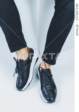 Men's legs in casual shoes of black color made of genuine leather, men on shoes in black sneakers. High quality photo Men's legs in casual shoes of black color made of genuine leather, men on shoes in black sneakers. High quality photo 137887198