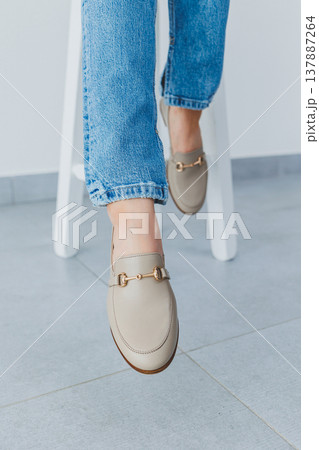 Woman's legs in trousers and beige leather shoes Woman's legs in trousers and beige leather shoes 137887264