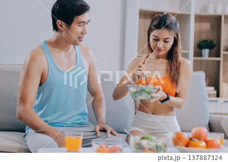 A happy couple prepares fresh vegetables, laughing and enjoying cooking a healthy meal together. A happy couple prepares fresh vegetables, laughing and enjoying cooking a healthy meal together. 137887324