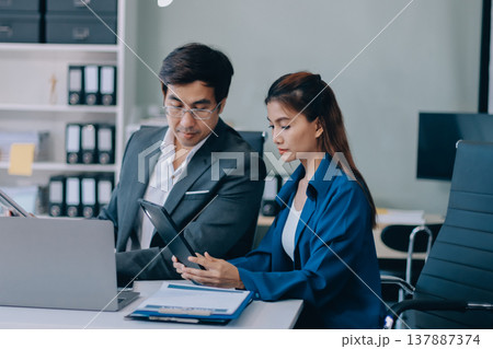Professionals listening to a discussion in an office 137887374