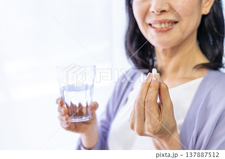 窓辺で薬を飲むシニア女性 137887512