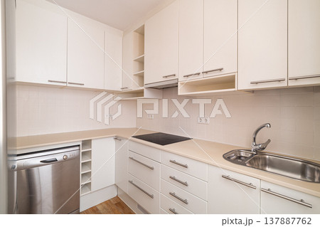 Modern kitchen with white cabinets, stainless steel appliances, and a clean countertop. The space is bright and minimalistic, ideal for cooking and dining. Modern kitchen with white cabinets, stainless steel appliances, and a clean countertop. The space is bright and minimalistic, ideal for cooking and dining. 137887762