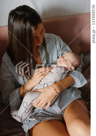 Loving Mother Holding Her Sleeping Newborn Baby 137888536