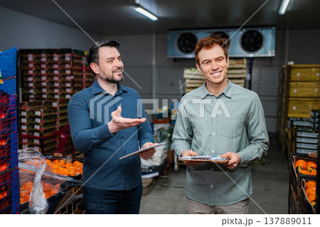Men inspecting fresh produce in food storage warehouse 137889011