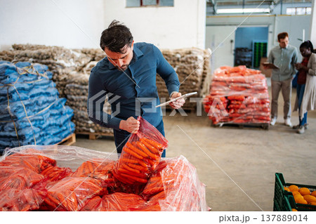 Man checking carrots quality in food warehouse 137889014