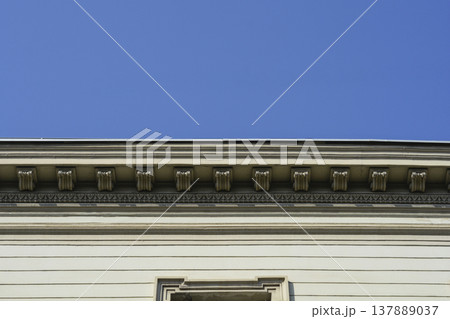 Classical Cornice with Dentil Molding against Blue Sky Classical Cornice with Dentil Molding against Blue Sky 137889037