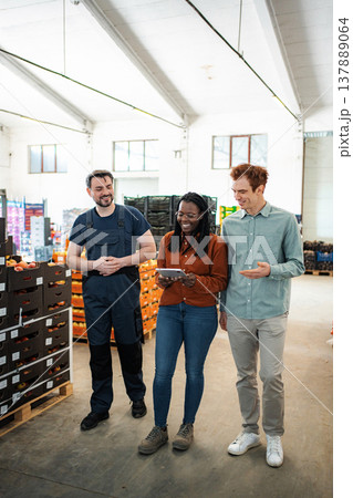 Warehouse workers collaborating on logistics using tablet technology Warehouse workers collaborating on logistics using tablet technology 137889064