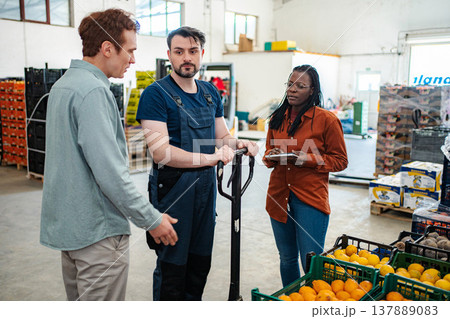 Warehouse workers discussing logistics and fresh produce distribution Warehouse workers discussing logistics and fresh produce distribution 137889083