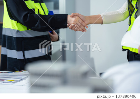 architects and engineers shake hands while working for teamwork. 137890406