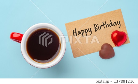 Happy birthday paper card with heart chocolate and coffee cup on blue background 137891216