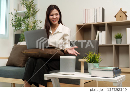 Smart Speaker Interaction. User engaging with smart speaker while working. 137892349