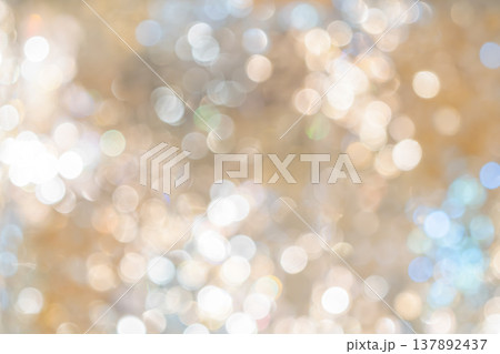 Golden bokeh lights with blurred circular highlights and warm tone creating an abstract light pattern suitable for luxury background use. 137892437