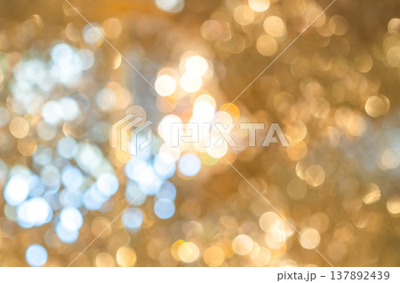 Golden bokeh lights with blurred circular highlights and warm tone creating an abstract light pattern suitable for luxury background use. Golden bokeh lights with blurred circular highlights and warm tone creating an abstract light pattern suitable for luxury background use. 137892439