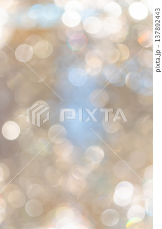 Golden bokeh lights with blurred circular highlights and warm tone creating an abstract light pattern suitable for luxury background use. 137892443