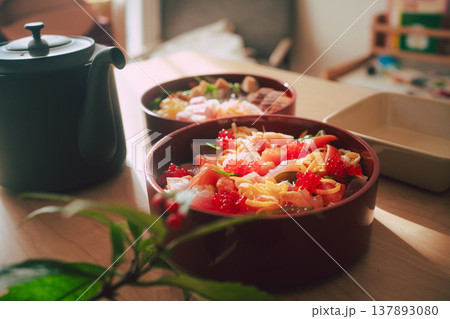 木製テーブルに置かれた鮮やかなちらし寿司と急須の和食膳 137893080