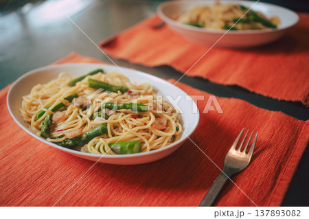 オレンジ色のマットに置かれたアスパラガスと魚介のパスタ 137893082