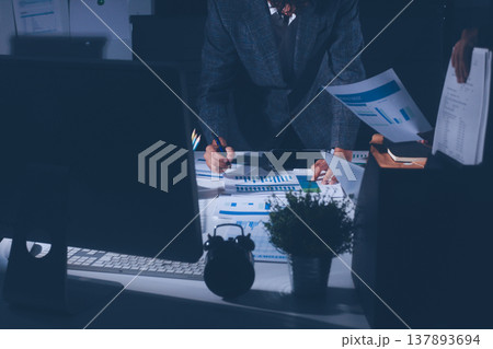 Professional photo of a person's hands reviewing a contract or legal document on a desk, for concepts of business, finance, and legal affairs 137893694