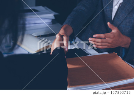 Professional photo of a person's hands reviewing a contract or legal document on a desk, for concepts of business, finance, and legal affairs 137893713
