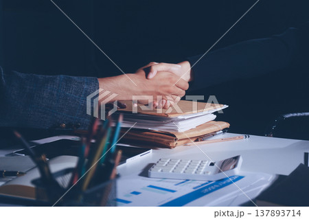 Professional photo of a person's hands reviewing a contract or legal document on a desk, for concepts of business, finance, and legal affairs 137893714