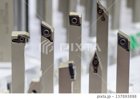 Close-up of a group of professional CNC turning tools and indexable carbide inserts for high-precision lathe machining. 137893898